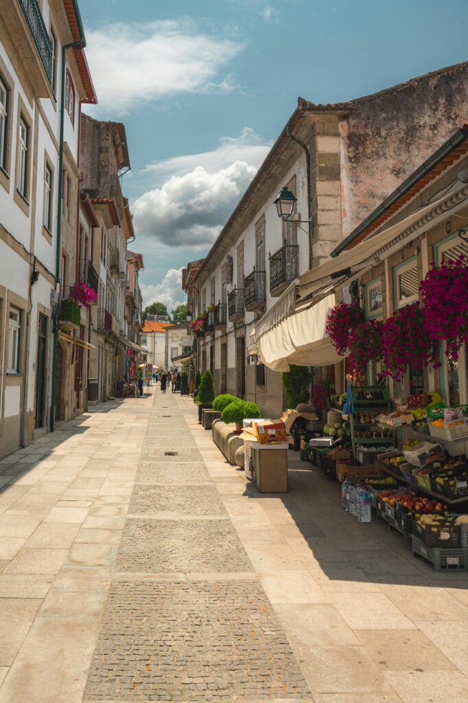 Explore a beautiful street in Ponte de Lima, Portugal, lined with historic buildings and vibrant market stalls.